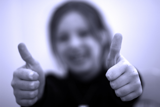 An image showing a child in a thumbs up pose