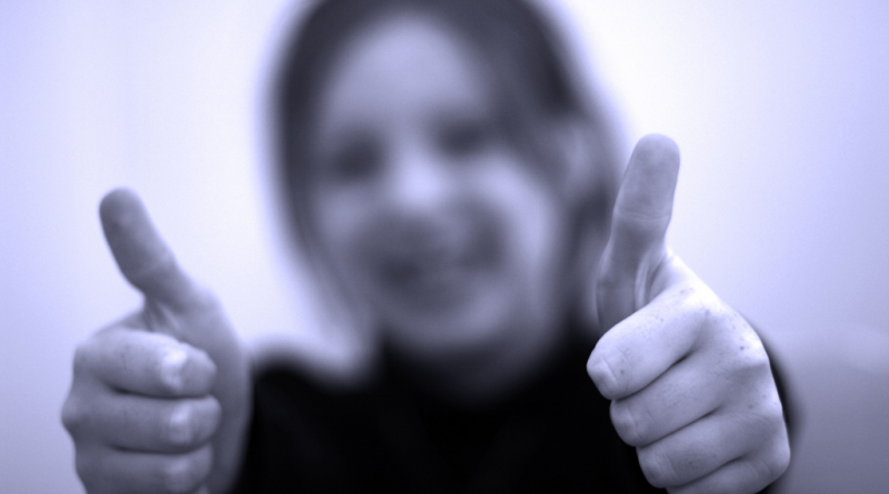 An image showing a child in a thumbs up pose