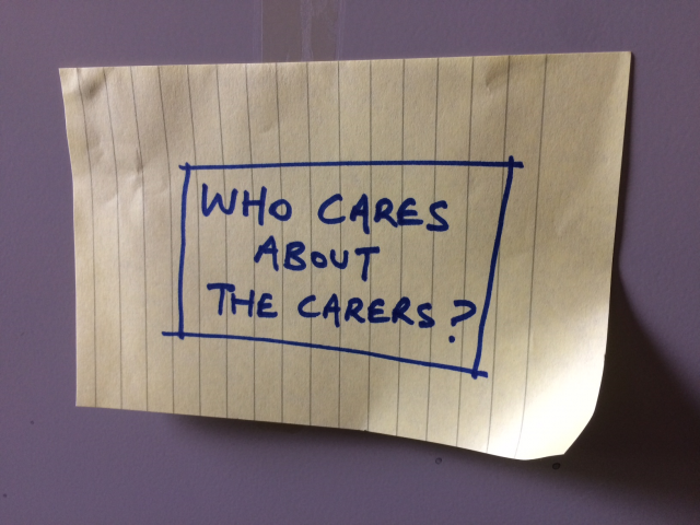 A note with writing which reads 'Who cares about the carers?'