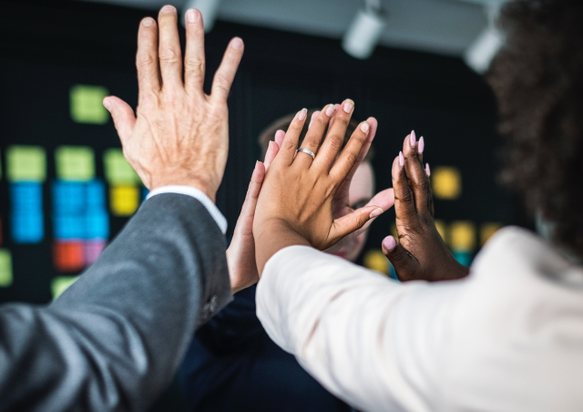 An image showing members of staff doing 'high fives'