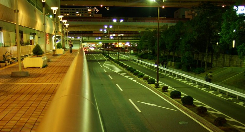 An image showing an urban road at night with very little traffic