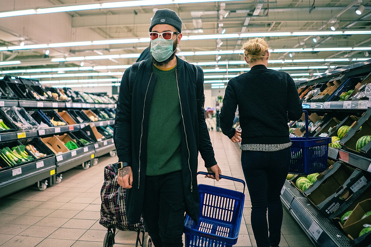 An image showing a shopper in a supermakrt wearing a face covering