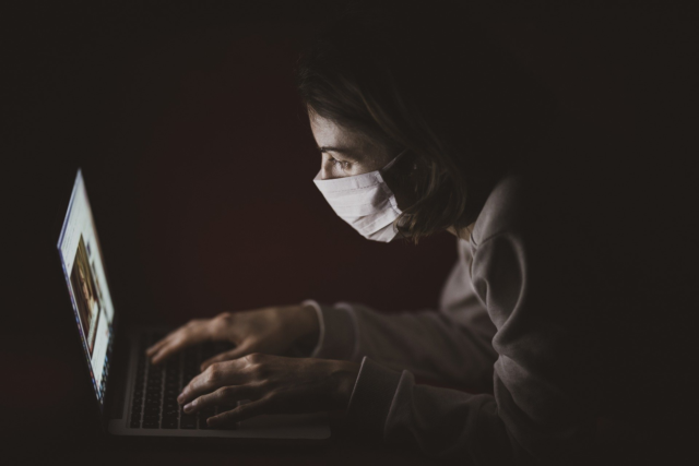 An image showing a person using social media while wearing a mask