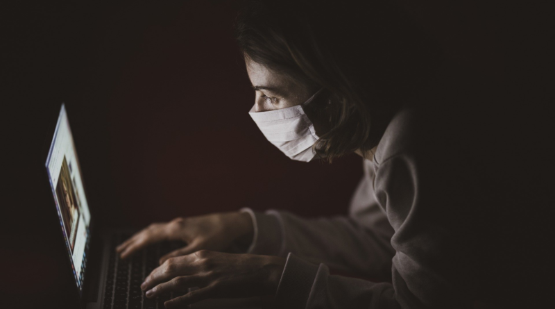 An image showing a person using social media while wearing a mask