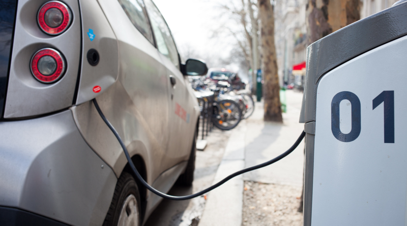 An image showing an electric car charging in the street