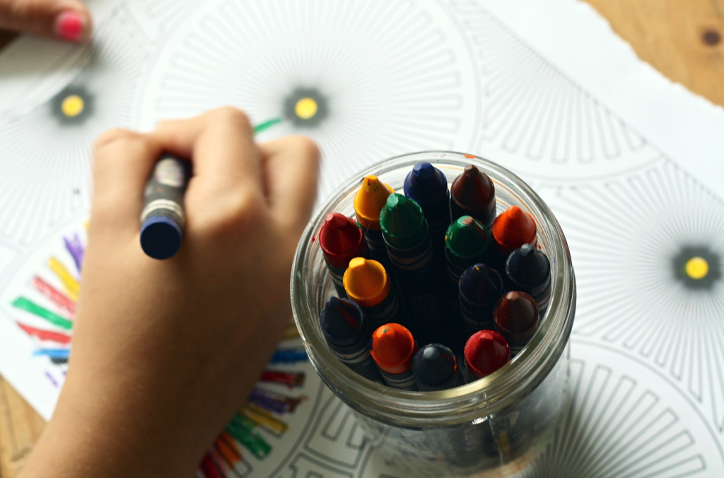 An image showing someone colouring with crayons