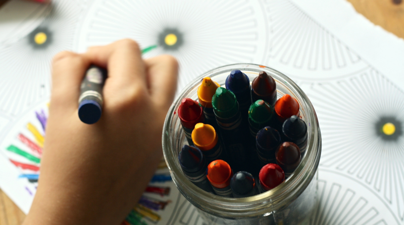An image showing someone colouring with crayons