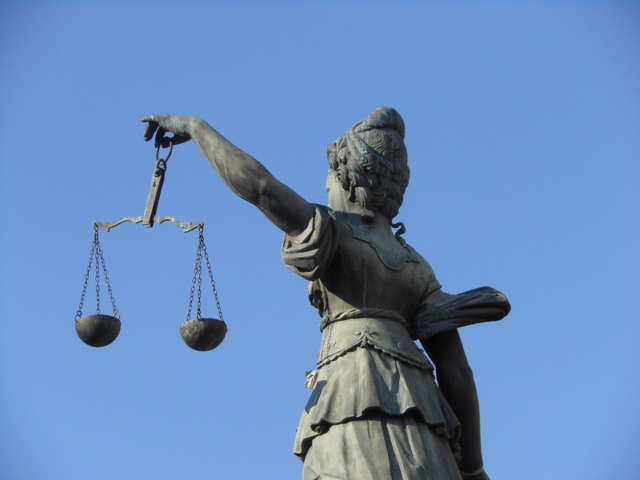 An image of a statue of a woman holding the scales of justice