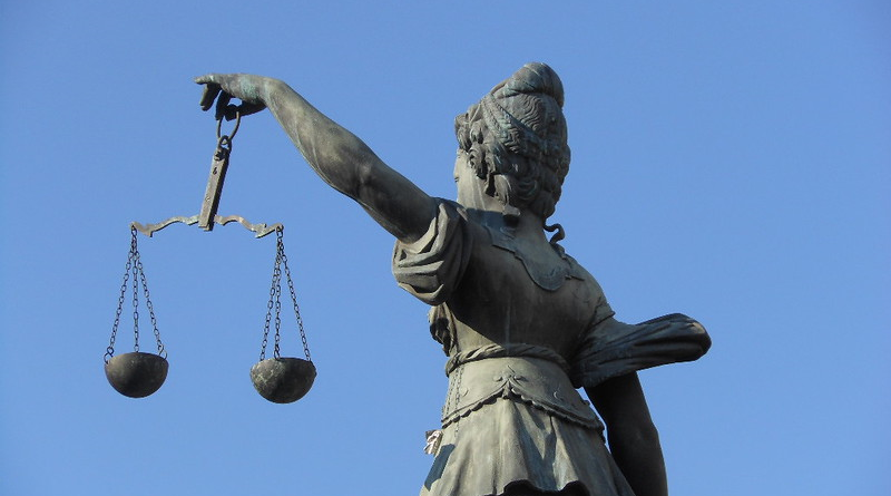 An image of a statue of a woman holding the scales of justice