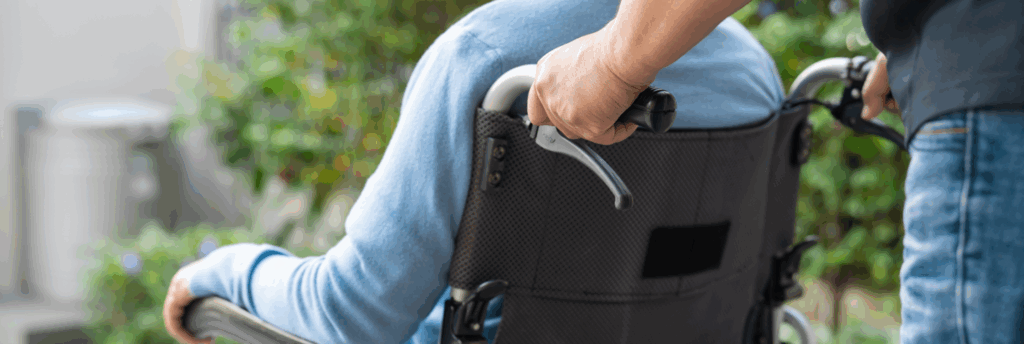 An image of a carer assisting a wheelchair user