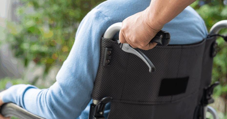 An image of a carer assisting a wheelchair user