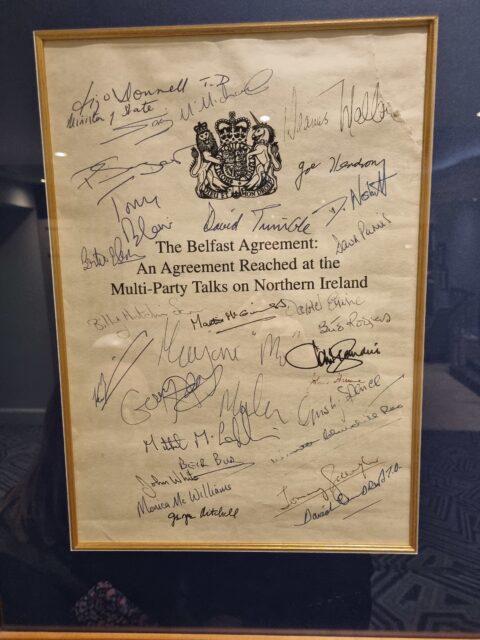 A photograph of the front page of the Belfast/Good Friday Agreement, signed by each of the parties