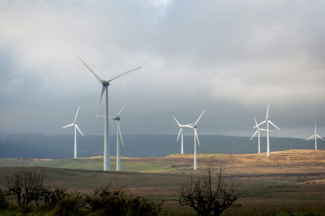 A photograph showing a set of white-coloured wind turbines on some hills in Northern Ireland