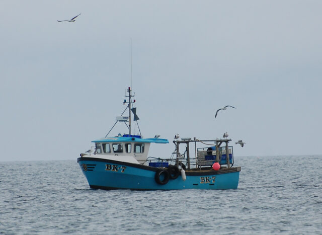 A photograph showing a small fishing vessel at sea