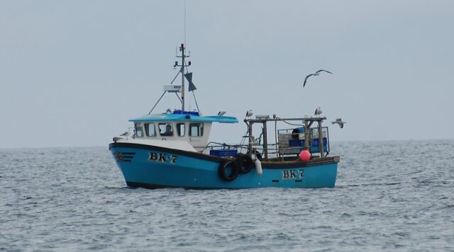 A photograph showing a small fishing vessel at sea