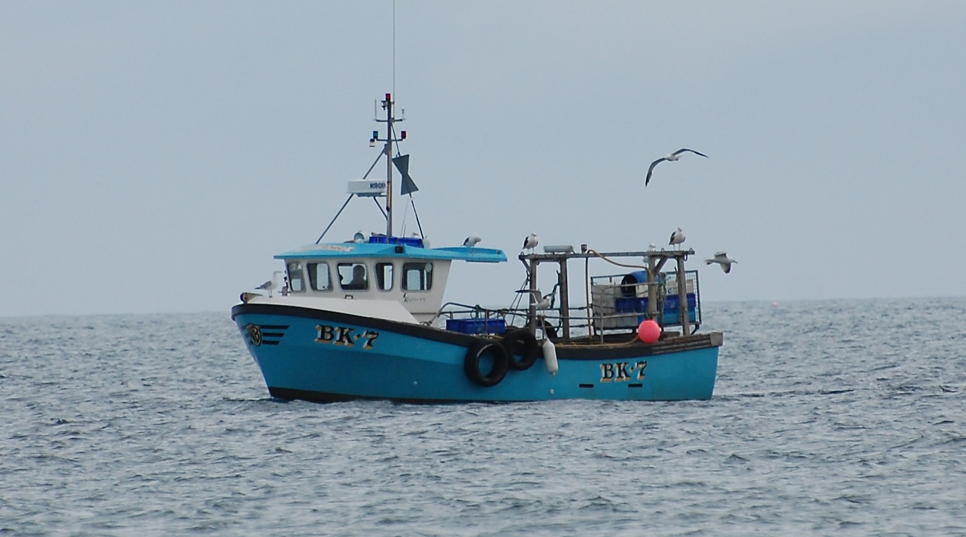 A photograph showing a small fishing vessel at sea